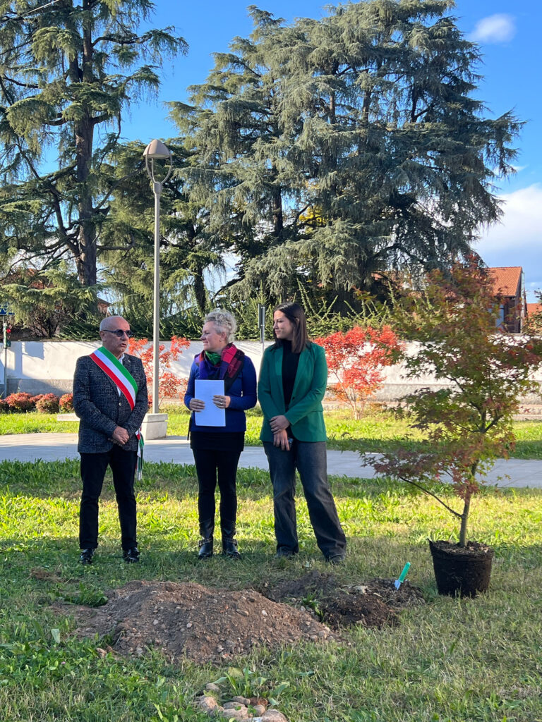Tre persone parlano accanto a un albero pronto per la piantumazione durante un’iniziativa ambientale legata alla mostra “L’eredità della vita” a Marcallo con Casone. Nella foto il sindaco di Marcallo con Casone