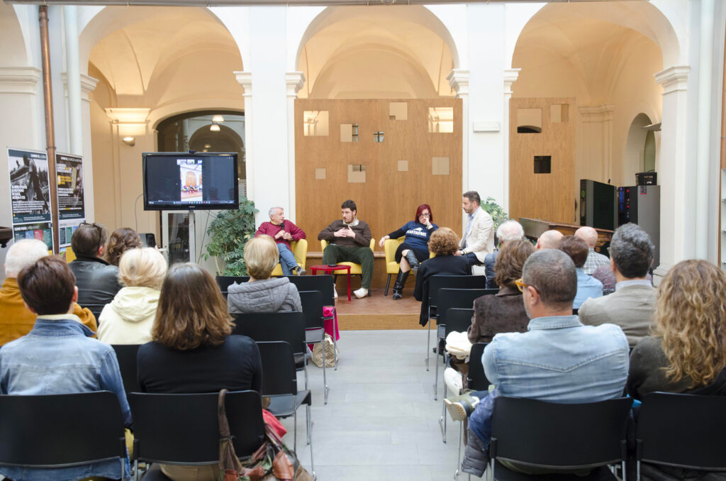 Persone di spalle ascoltano una conferenza
