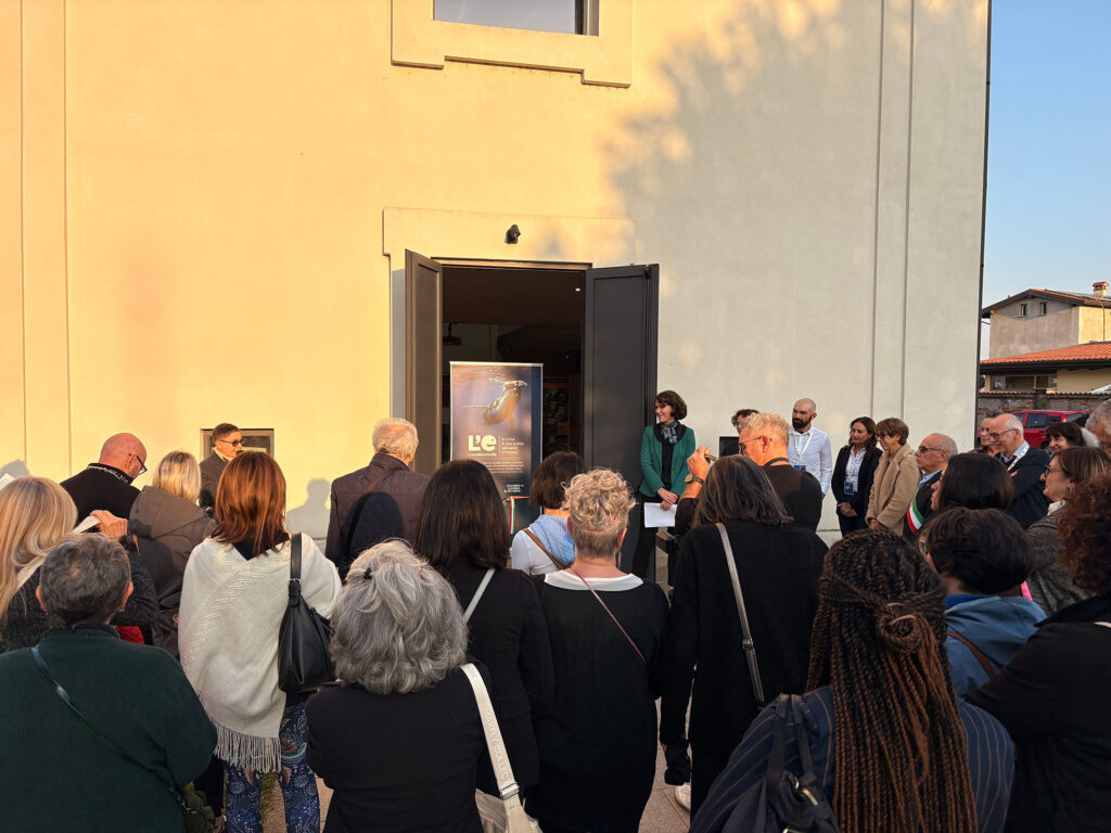 Un gruppo di persone partecipa all’apertura ufficiale della mostra “L’eredità della vita” davanti all’ingresso della sala espositiva a Marcallo con Casone.