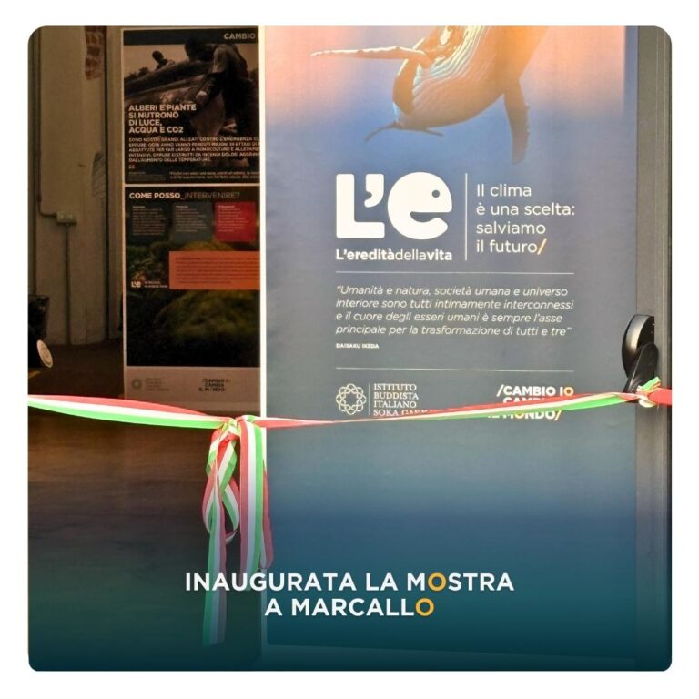 Nastro tricolore pronto per il taglio durante l’inaugurazione della mostra “L’eredità della vita – Il clima è una scelta: salviamo il futuro” a Marcallo. Sullo sfondo, i pannelli espositivi e il logo dell’Istituto Buddista Italiano Soka Gakkai.