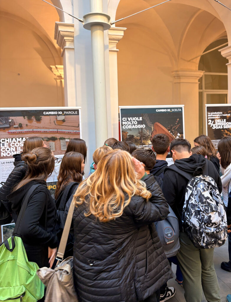 alcuni giovani di spalle guardano i pannelli della mostra l'eredità della vita. sui pannelli si legge in grande "Ci vuole molto coraggio".