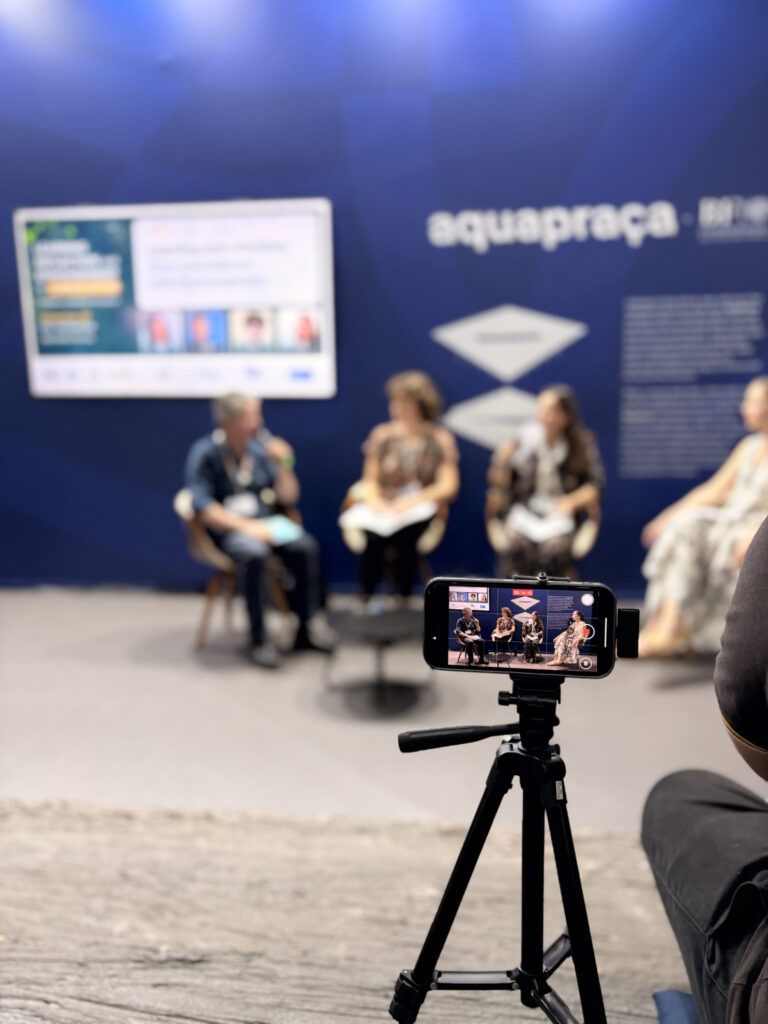Primo piano di una videocamera su treppiede che registra il panel “Learning, Reflection and Empowerment for Climate Action” alla COP30 di Belém.