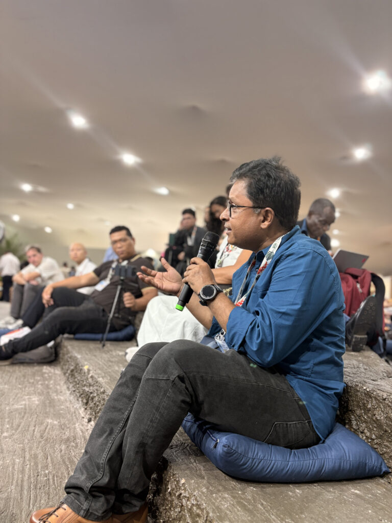 Un partecipante interviene con un microfono durante il dialogo “Learning, Reflection and Empowerment for Climate Action” alla COP30 di Belém.
