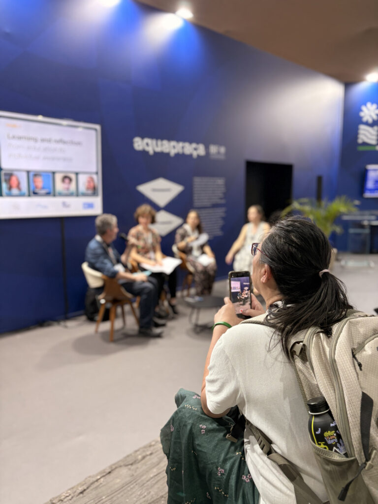 Una persona fotografa i relatori del panel “Learning, Reflection and Empowerment for Climate Action” nel padiglione Italiano alla COP30.