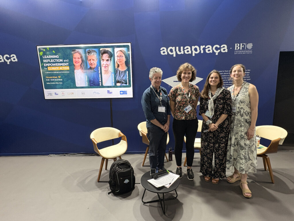 I quattro relatori del panel “Learning, Reflection and Empowerment for Climate Action” posano insieme davanti al monitor con la locandina dell’evento alla COP30 di Belém.