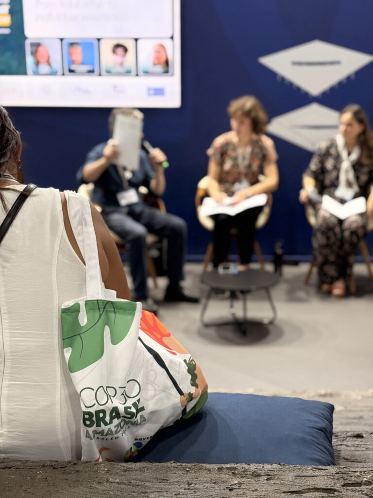 Parte del pubblico segue il dialogo “Learning and Reflection: from education to individual awareness” alla COP30, con i relatori seduti sul palco.