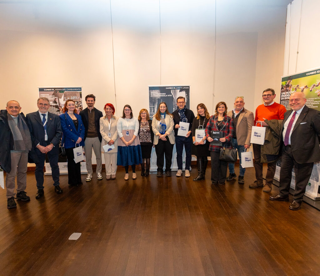 Organizzatrici, organizzatori e ospiti posano insieme davanti ai pannelli della mostra.