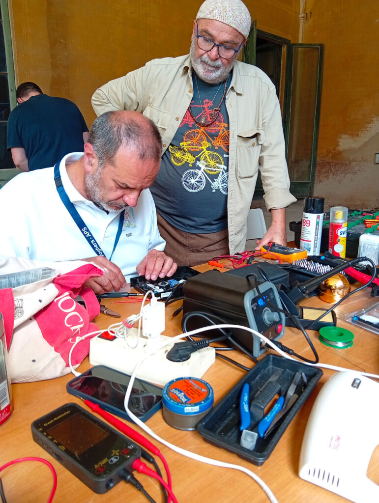Due uomini lavorano con attrezzi elettrici per riparare un vecchio elettrodomestico rotto