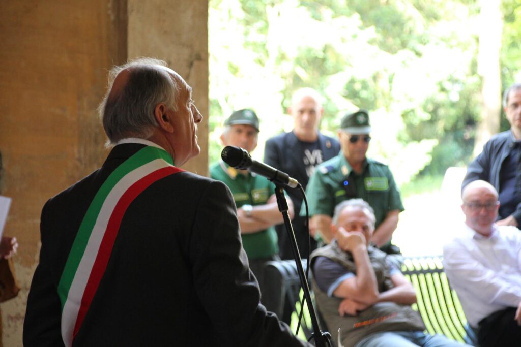 Sindaco con fascia tricolore parla al pubblico durante l’inaugurazione ufficiale.
