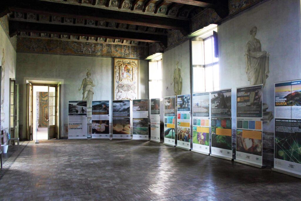 Vista ampia della sala espositiva con pannelli informativi e decorazioni storiche alle pareti.