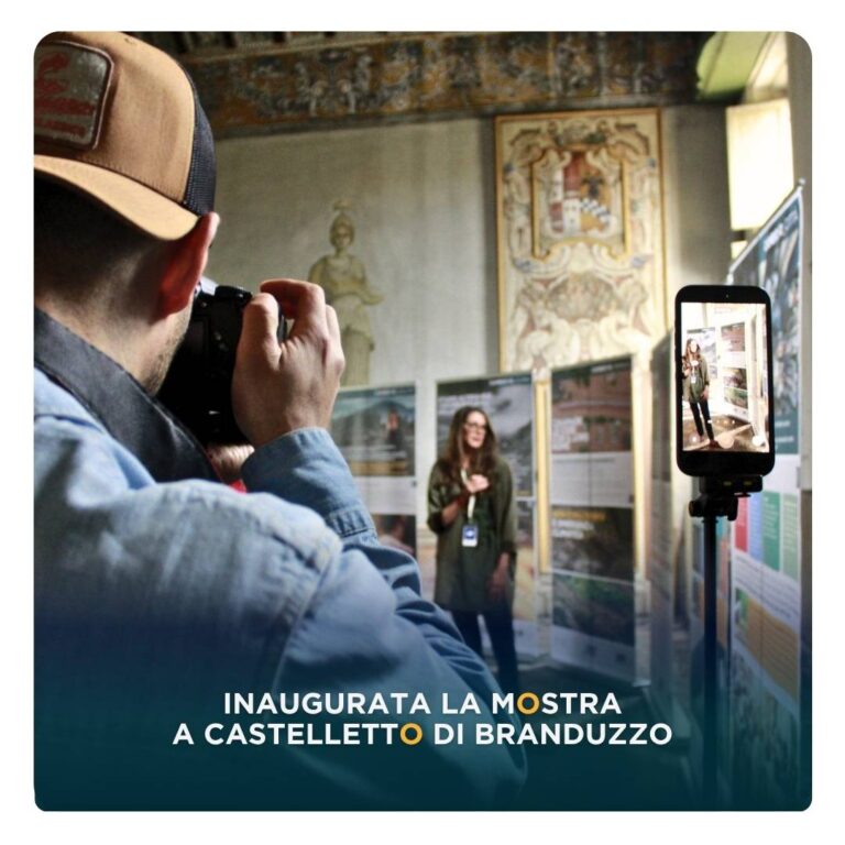 Cover articolo di blog con un fotografo in primo piano che fa una foto a una guida davanti i pannelli della mostra "L'eredità della vita" e la scritta "Inaugurata la mostra a Castelletto di Branduzzo"