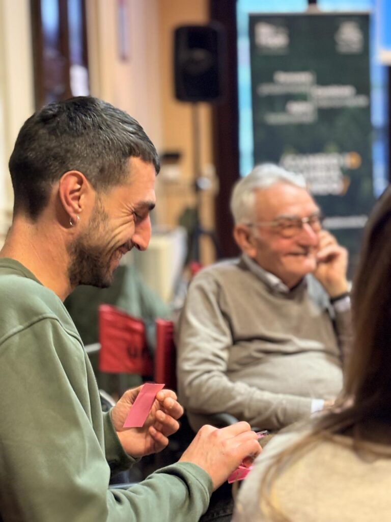 Ragazzo in primo piano sorridere durante un momento di condivisione e ascolto tra generazioni durante il laboratorio partecipativo.