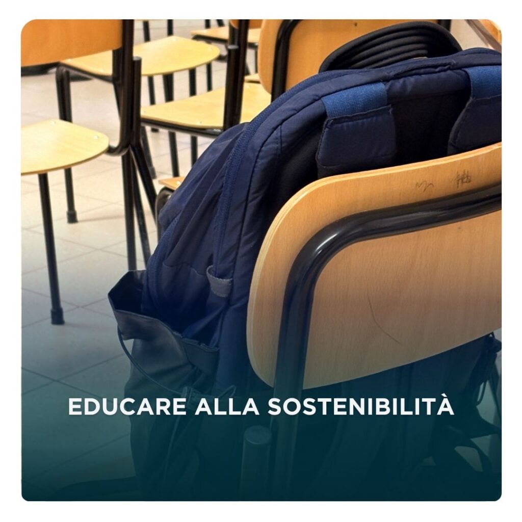Copertina dell'articolo del blog. Uno zaino poggiato su una sedia di una classe con scritto sopra "Educare alla sostenibilità: il viaggio di “Cambio io, cambia il mondo” nelle scuole"